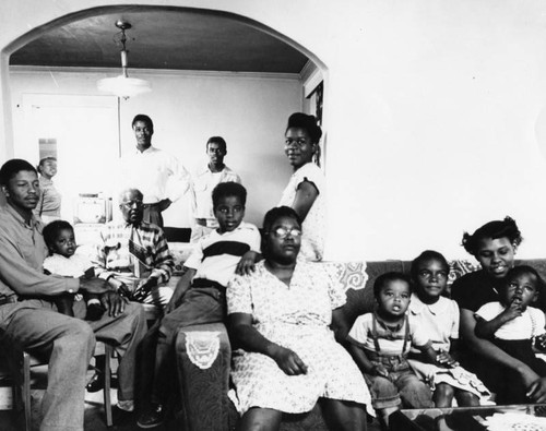 Family of 13 poses inside their dwelling