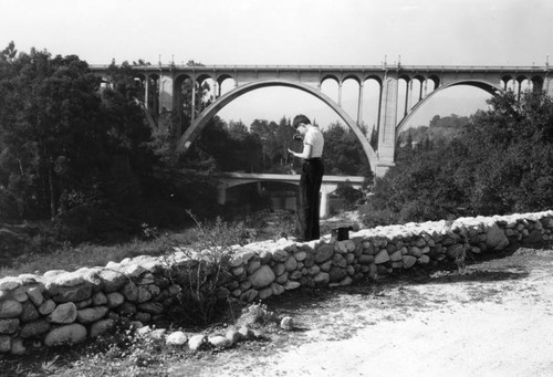 Young boy takes a photo of the bridge