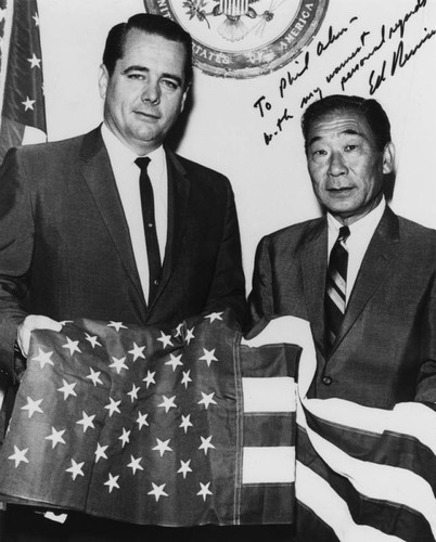 Philip Ahn and congressman holding flag