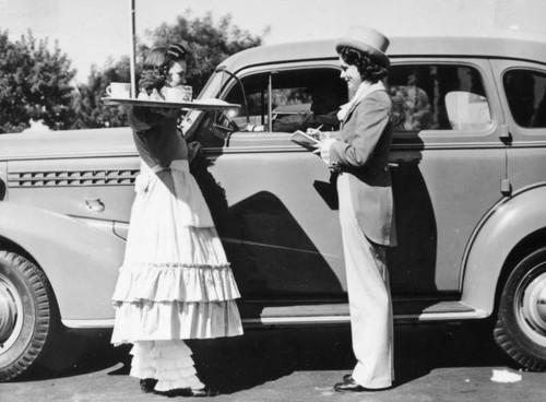 Two carhops taking an order