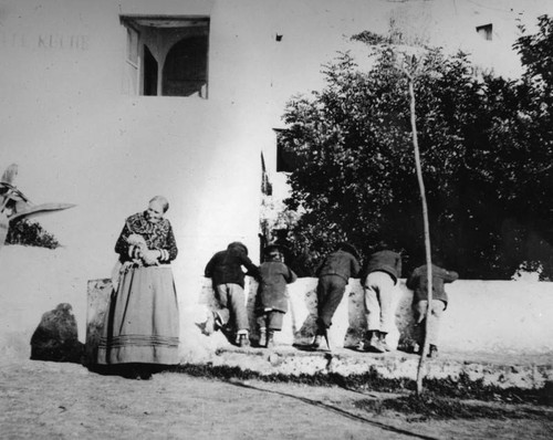 Five children leaning over wall