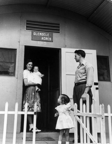 Young family outside their quonset "shed"