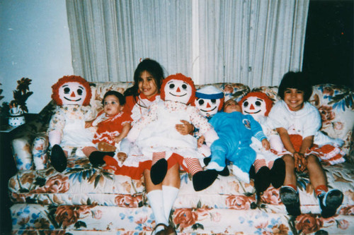 Siblings on couch with dolls