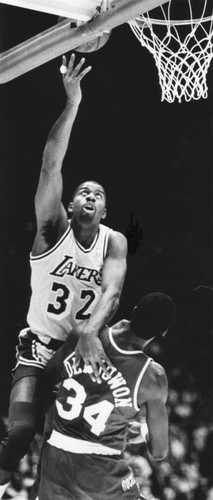 Magic Johnson scores as he gets past an opponent