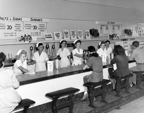 Employees and customers at a Currie's Ice Cream parlor