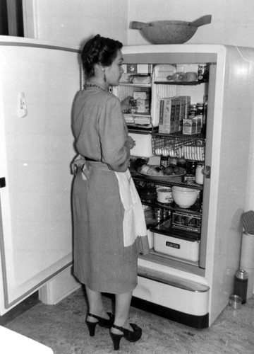 Woman looking in refrigerator in suburban home