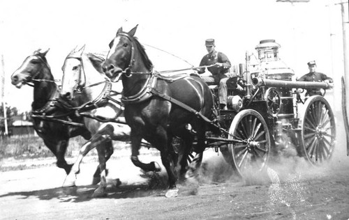 Old-time fire engine drawn by speedy horses