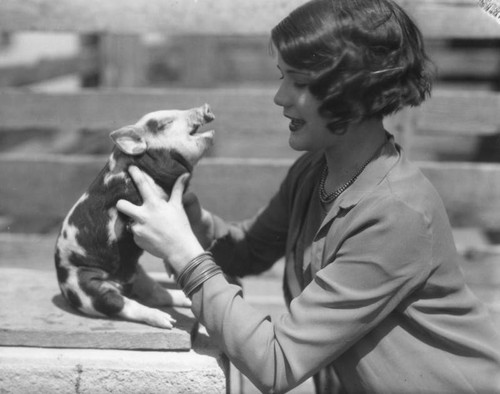 Woman holding baby pig