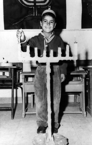 Jewish boy lights Hannukah candles