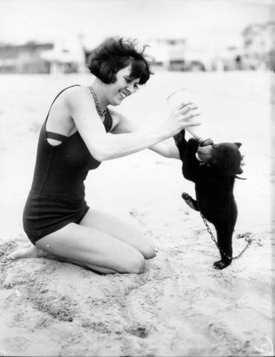 Woman with bear cub on beach