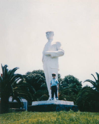 Little boy poses with statue