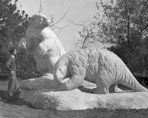 Sculptor viewing giant sloth statues