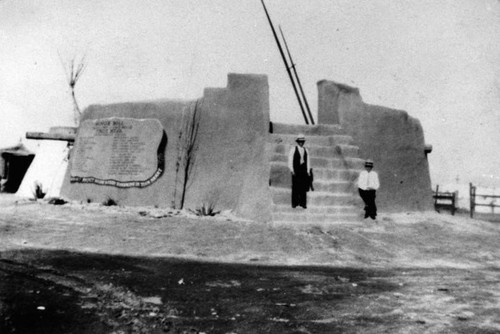 Adobe building with two men on stairs