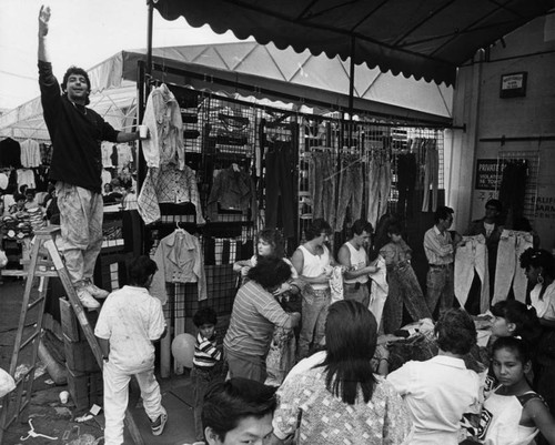 Vendor "hawks" his clothing to large crowd of shoppers