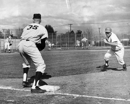 Tony Davilla, right, tries to get back to base safely