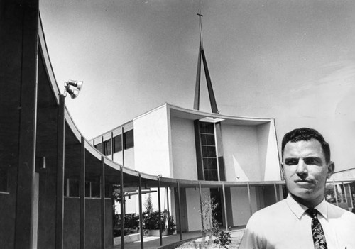 The Rev. Frank L. Williams stands in front of new church buildings