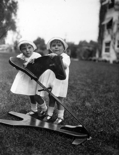 Twins with rocking horse