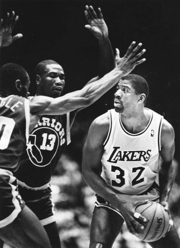 Magic Johnson blocked by two guards of the Golden State Warriors