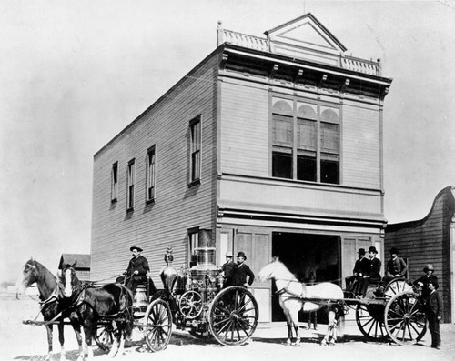 Horse-drawn fire engines at firehouse