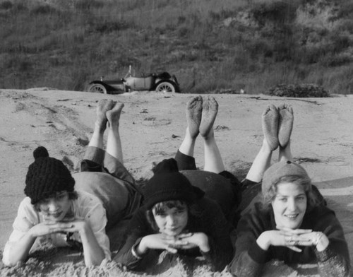 Three young women posing at the beach