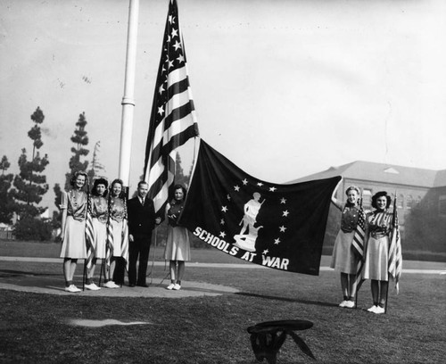 Mr. Wood and Fremont High School girls' drill team displaying Minute-Man flag