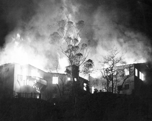 Flames tower above burning houses in Hollywood Hills area