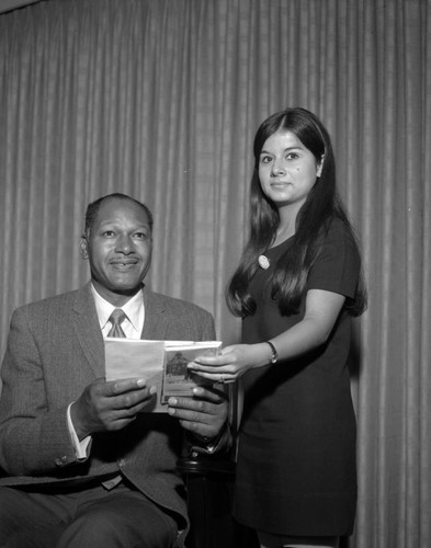 Councilman Tom Bradley holding a campus guide brochure