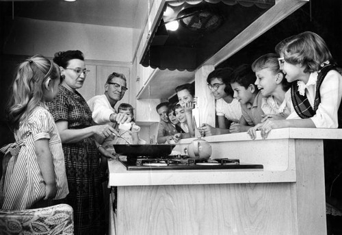 Hungry eyes watch Mrs. Sawlsville prepare Thanksgiving dinner for her family of 12 and five guests