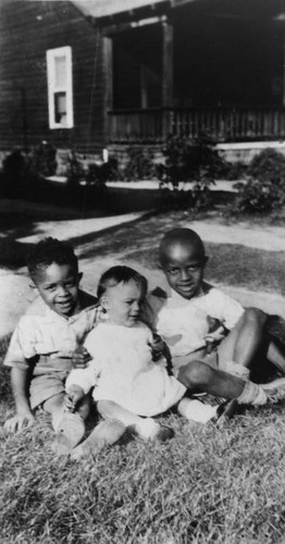 Children sitting in front of house