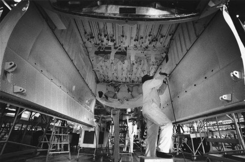 Employee working on plane at Lockheed facility — Calisphere