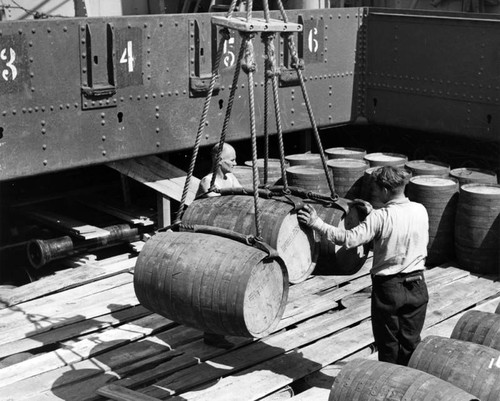 Beer barrels checked by ships crewmen