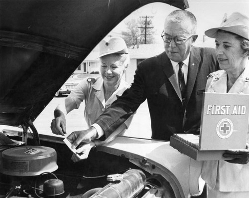 Burbank Red Cross workers give 'first aid' to the engine of their used station wagon