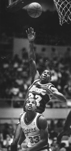 Magic Johnson shoots over Ken Norman