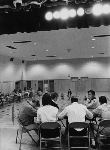 Grant High School actors rehearse, students around table