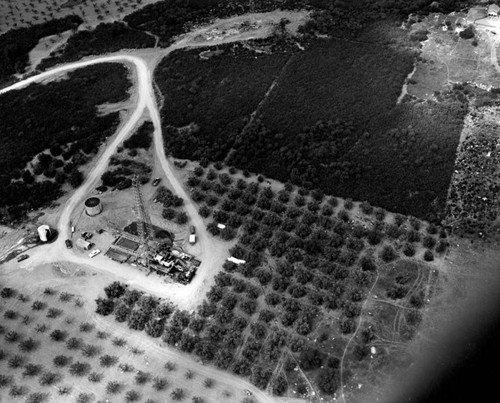 Aerial, oil derrick on farm land