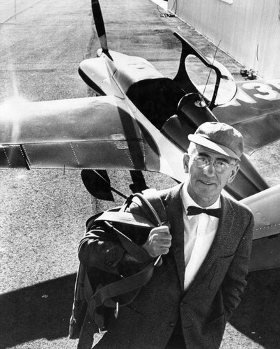 Dewey, parachute in hand, prepares to fly home