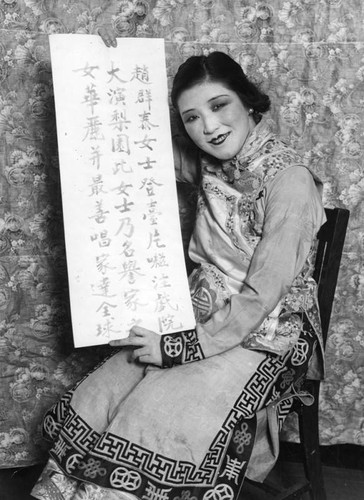 Jue Quong Tai holding banner with Chinese writing