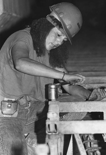 Construction worker, Debbie Eitle works on supports for rails in Flower Street tunnel