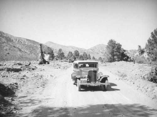 1931 Auburn driving past an excavator, Mojave Desert