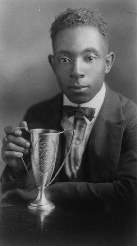 Young man with an academic trophy