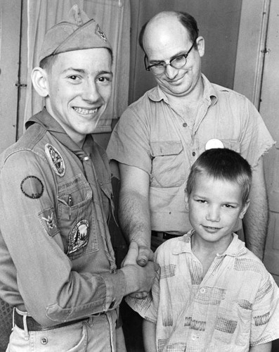 Raymond Schnitger, San Fernando, congratulates Boy Scout