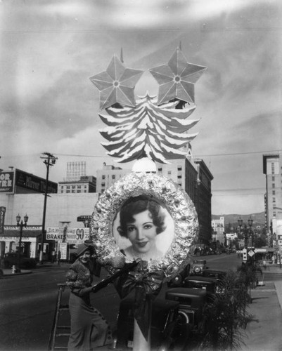 Claudette Colbert on ladder on Hollywood Boulevard