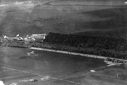 Thousands watch a biplane in low flight