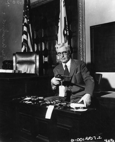 George A. Crawford examining guns, view 2