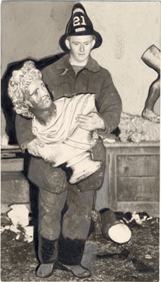 [Fireman El Aitkeb carrying a bust of Apollo from the site of a fire at Lowell High School]