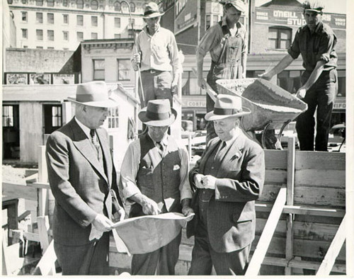 [Alexander Watchman, Joseph Stuart and Dr. Howard M. McKinley standing together on the site of Hospitality House]