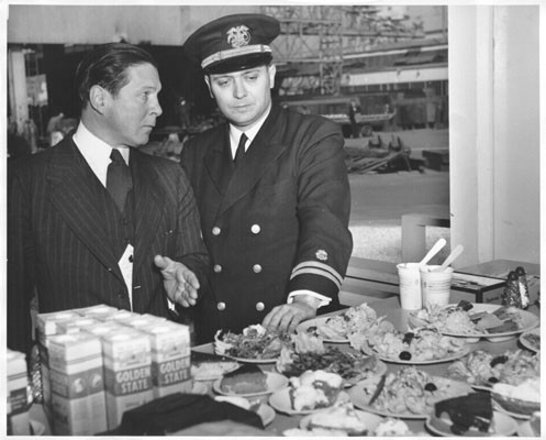 [William E. Broeg and Dr. Robert S. Goodhart inspecting the salad counter of the "fast-feed" unit in the Bethlehem Steel Company's San Francisco shipyard]