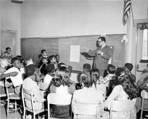 [Teacher showing students a snake in a science class at John Swett School]