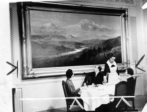 [Three individuals looking at a Palace Hotel painting]