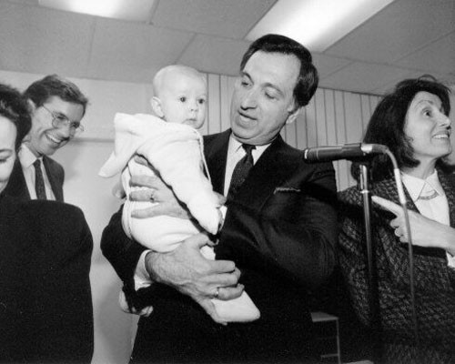 [Art Agnos holding child with Nancy Pelosi, Kevin Shelley, and Angela Alioto]